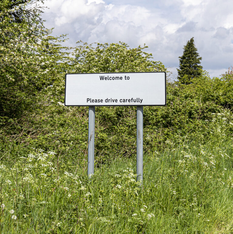 Rural welcome sign with a blank place-name line